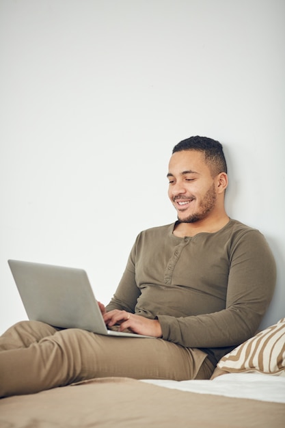 Homem de raça mista, usando o laptop em casa