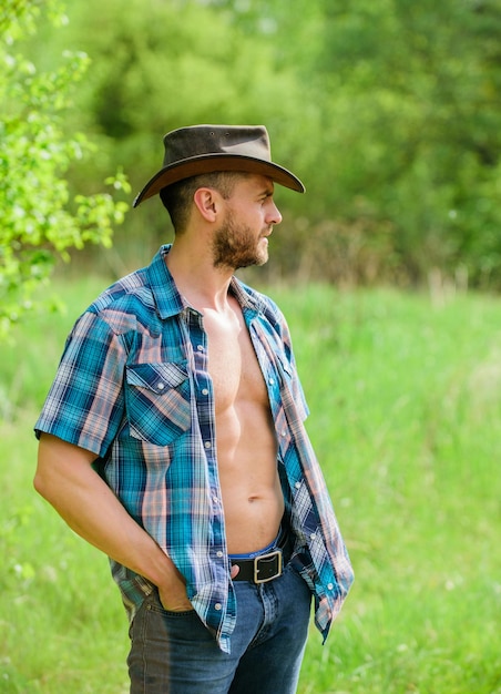 Homem de rancho musculoso com chapéu de cowboy agricultor sexy relaxa a agricultura e a agricultura tempo de cultivo para o intervalo Fazenda Eco Colheita feliz dia da terra Vida ecológica Melhor serviço para você