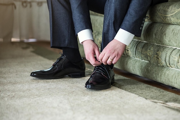 Homem de sapatos de roupas de empresário se preparando para a manhã do noivo antes da cerimônia de casamento