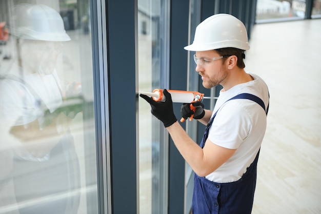 Homem de serviço instalando janela com chave de fenda