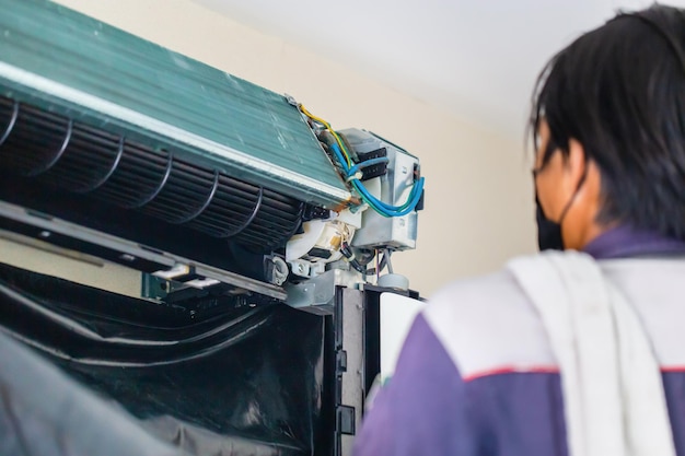 Homem de serviço técnico limpando ar condicionado dentro de casa Reparador consertando ar condicionado moderno Conceitos de manutenção e reparação