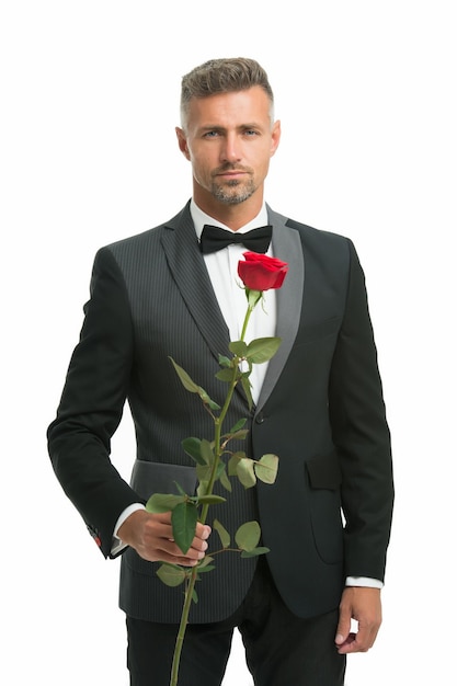 Homem de smoking com flor rosa. feliz Dia dos namorados. ocasião especial. estilo formal masculino de roupa. homem elegante de terno e gravata homem sexy em encontro romântico. Código de vestimenta black tie para eventos noturnos.