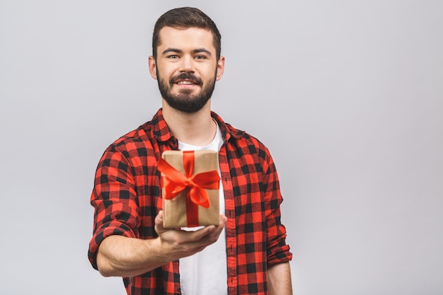 Homem de sorriso na camisa vermelha com a caixa de presente isolada contra o fundo branco.