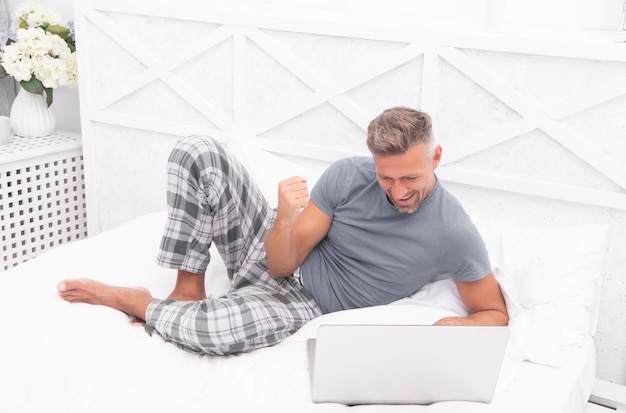 Homem de sucesso freelancer em casa homem freelancer Em casa na cama homem freelance em casa