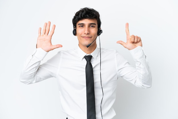 Homem de telemarketing trabalhando com um fone de ouvido isolado no fundo branco contando sete com os dedos