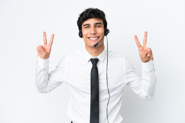 Homem de telemarketing trabalhando com um fone de ouvido isolado no fundo branco, mostrando sinal de vitória com as duas mãos