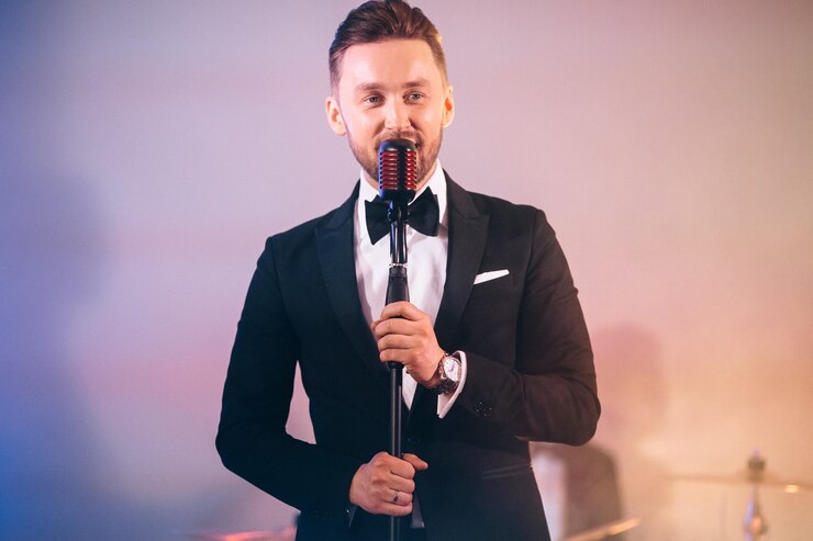 Foto homem de terno cantando no palco