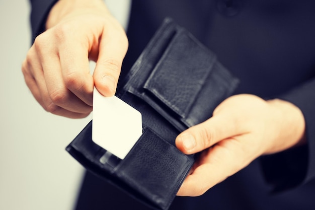 Homem de terno com carteira e cartão de crédito.