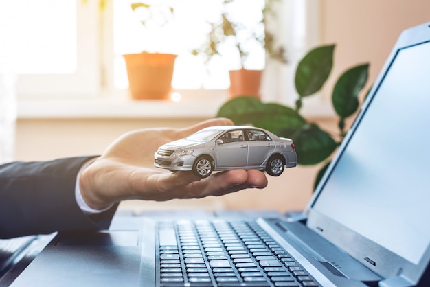 Homem de terno, trabalhando com o laptop, segurando nas mãos o