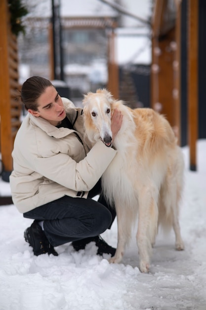 Homem de tiro completo com cachorro galgo fofo