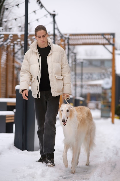 Foto homem de tiro completo com cachorro galgo fofo