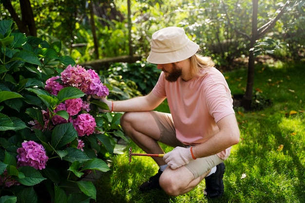 Homem de tiro completo cuidando de flores