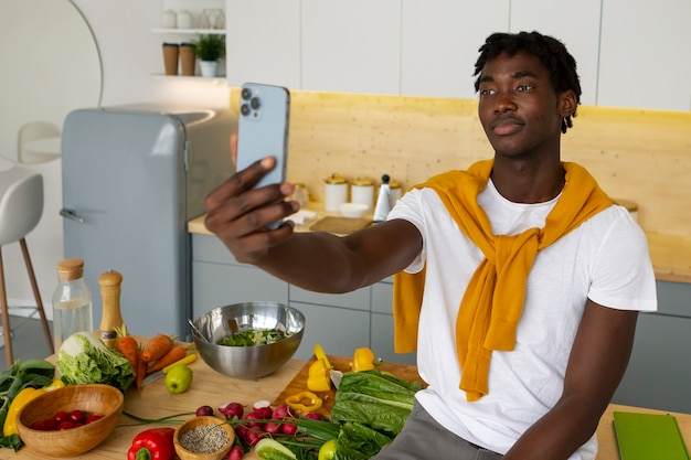 Homem de tiro médio cozinhando com smartphone