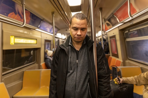 Homem de tiro médio dormindo no metrô