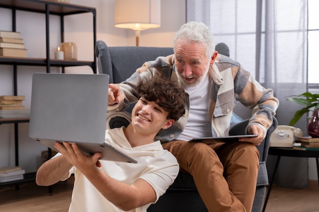 Foto homem de tiro médio e adolescente olhando para laptop