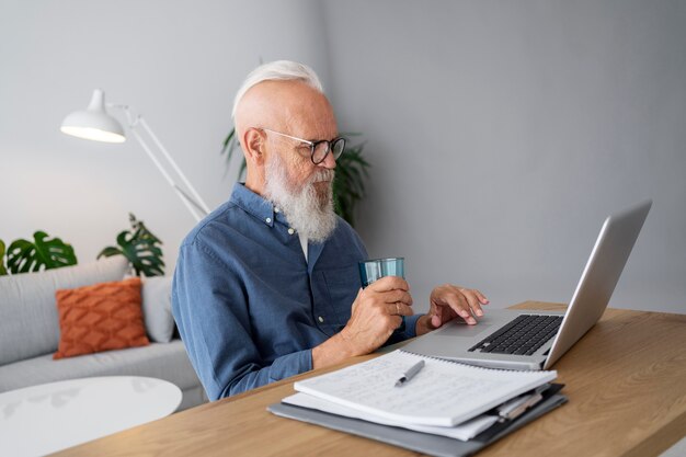 Foto homem de tiro médio estudando na mesa com um laptop