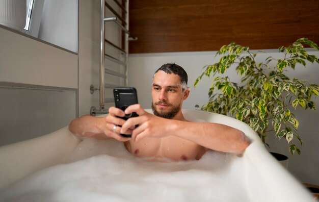 Foto homem de tiro médio tomando banho