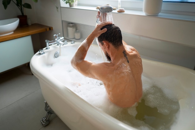 Homem de tiro médio tomando banho