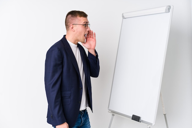 Homem de treinamento novo que mostra um quadro branco que shouting e que guarda a palma perto da boca aberta.