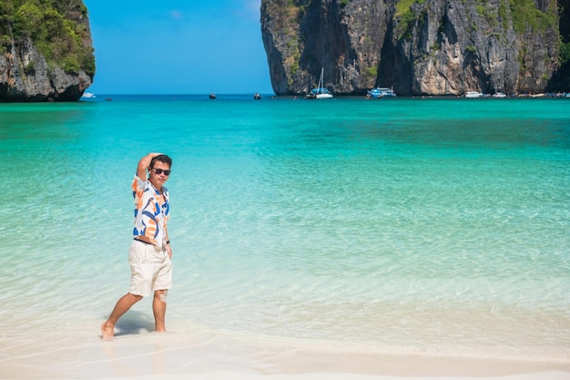 Homem de turista feliz na praia de Maya Bay, na ilha de Phi Phi, Krabi Tailândia, destino de referência no Sudeste Asiático, férias e conceito de férias