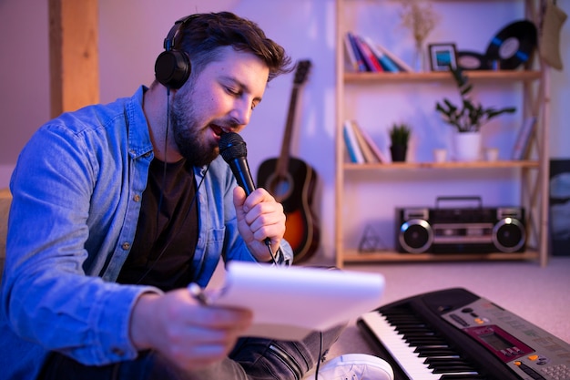 Foto homem de vista lateral cantando em casa