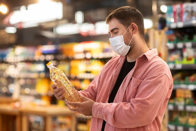 Foto homem de vista lateral fazendo compras com máscara