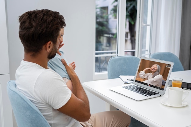 Foto homem de vista lateral fazendo uma chamada de vídeo