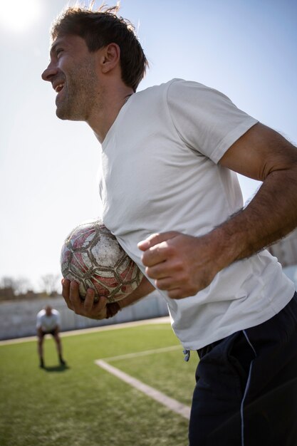 Foto homem de vista lateral jogando futebol