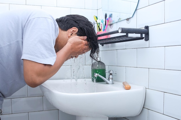 Homem de vista lateral lavando o rosto no banheiro tratamento facial na pia Estilo de vida de cuidados com a pele masculino