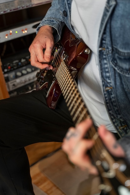 Foto homem de vista lateral tocando violão no estúdio
