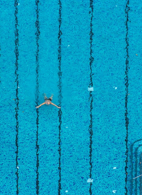 Homem de vista superior nadando na piscina. Plano de fundo para esporte e lazer nas férias.