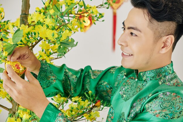 Homem decorando uma árvore de damasco em flor