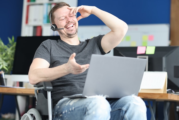 Homem deficiente em fones de ouvido se comunicando por link de vídeo. Conceito de emprego de pessoas com deficiência