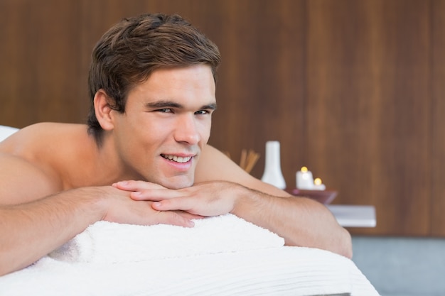 Homem deitado na mesa de massagem no centro de spa