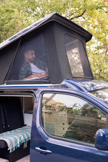 Homem deitado na tenda pop-up de sua caravana