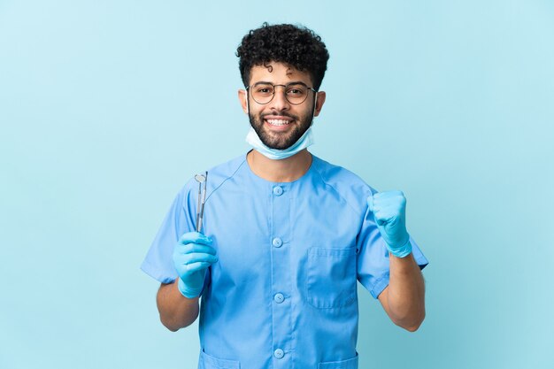 Homem dentista marroquino segurando ferramentas isoladas