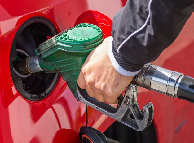 Foto homem derrama gasolina no tanque do carro