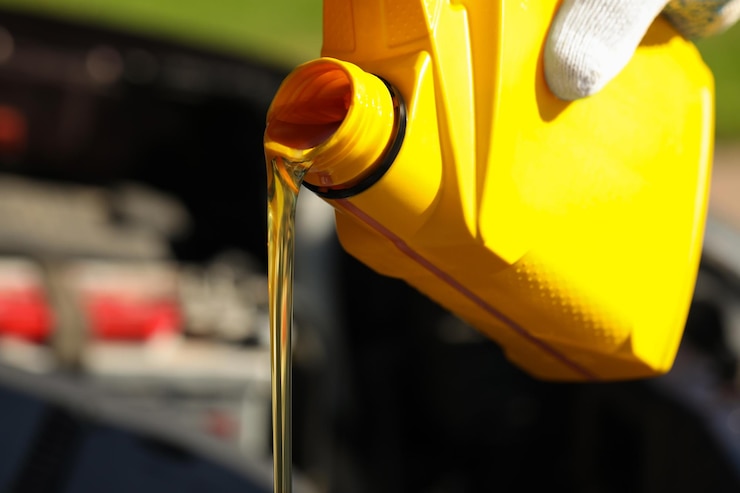 Foto homem derramando óleo de motor de um recipiente amarelo fechado espaço para texto