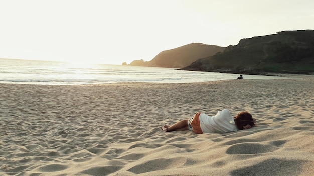 Foto homem descansando na praia contra o céu claro de manhã