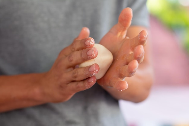 Homem desconhecido amassar comida de Natal. mãos com pão cru pronto para assar. bolinhos de natal