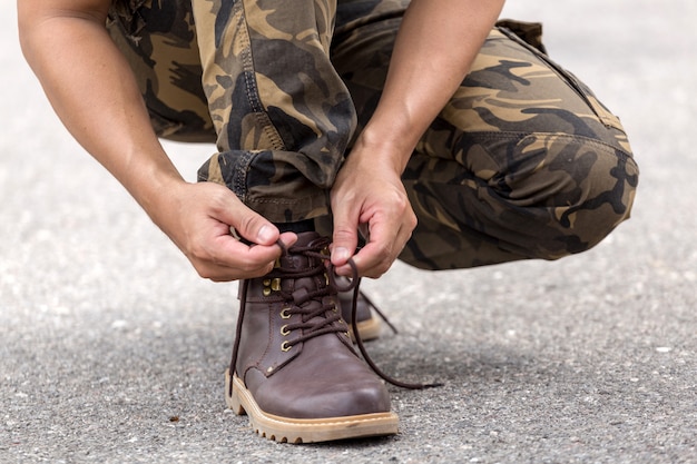 Homem, desgastar, carga, calças, e, amarrando, a, laços, ligado, couro, sapatos, botina