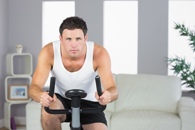 Homem desportivo bonito exercitando em bicicleta