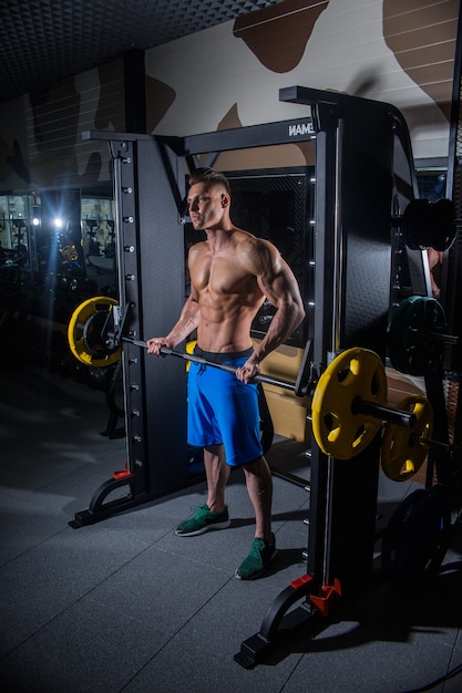 Homem desportivo com grandes músculos e costas largas treina no ginásio, fitness e musculação abdominal. Homem sexy no ginásio com halteres. Rússia, Sverdlovsk, 2 de junho de 2018