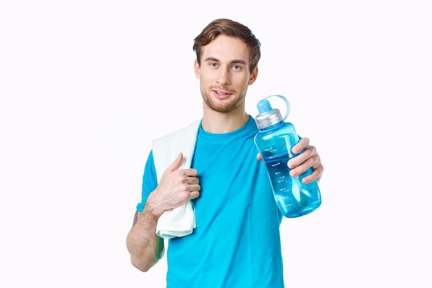 Homem desportivo de camisa azul, garrafa de água, toalhas de treino, foto de alta qualidade.