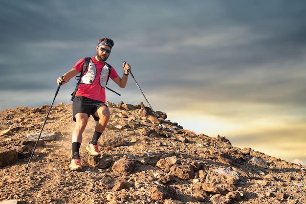 Homem desportivo desce do pico rochoso