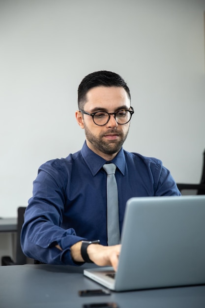 Homem digitando em um computador, homem sentado em um escritório respondendo e-mails