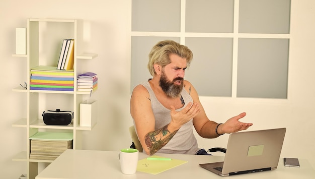 Homem digitando no computador estilo de vida sedentário preguiçoso homem no local de trabalho usa tecnologia Trabalhando Freelance Local de trabalho com laptop na mesa em casa Homem caucasiano trabalhando em home office