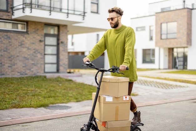 Homem dirige scooter elétrico com pacotes de papelão