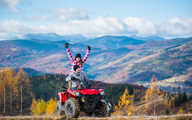 Homem, dirigindo, atv, quad, bicicleta, mulher senta-se, ele, e, levantado, dela, mãos cima, ligado, um, estrada montanha