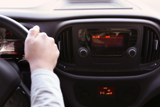 Homem dirigindo carro enquanto ouve rádio